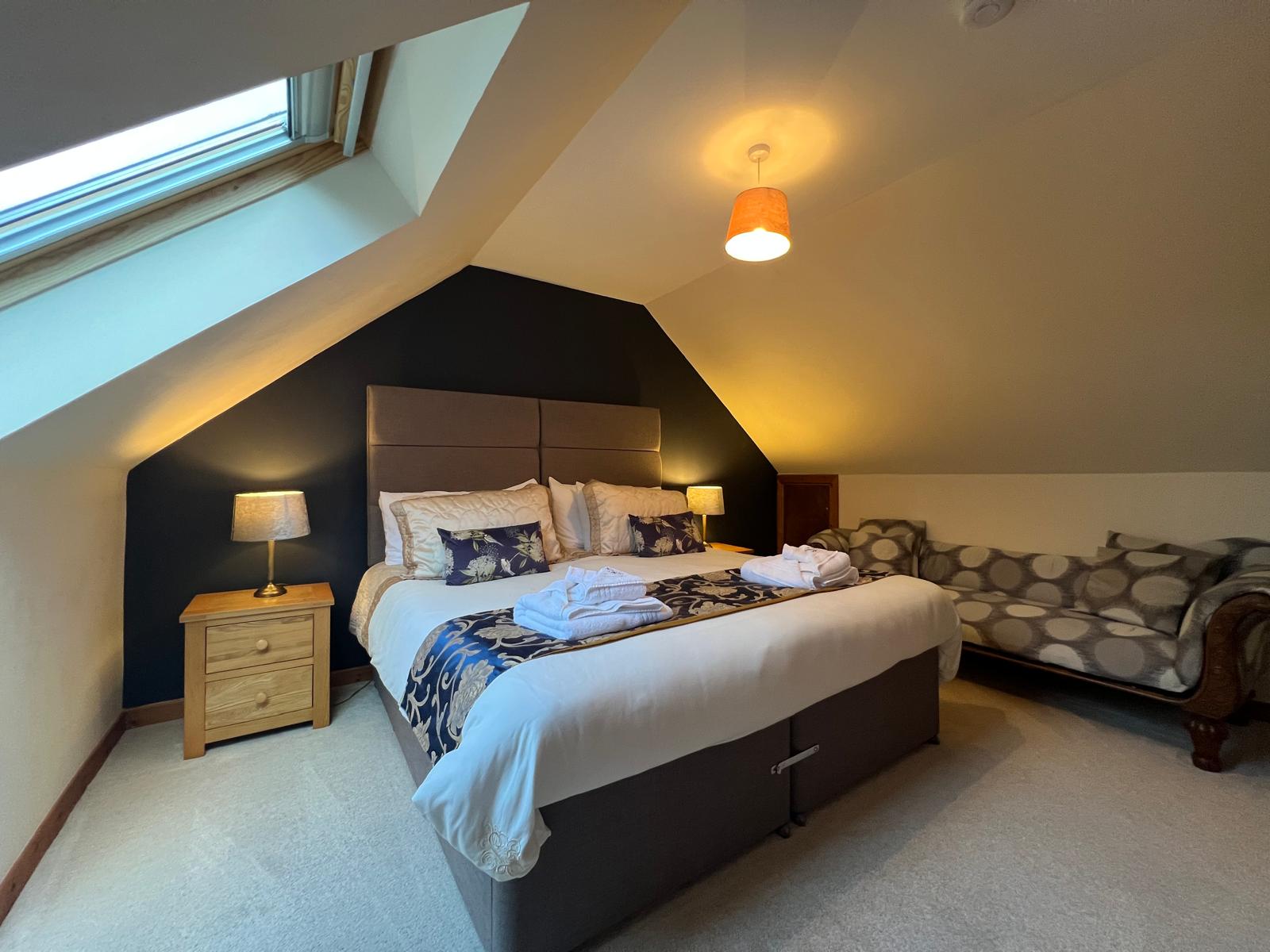 Lindfields bedroom 1 with feature wall and skylight