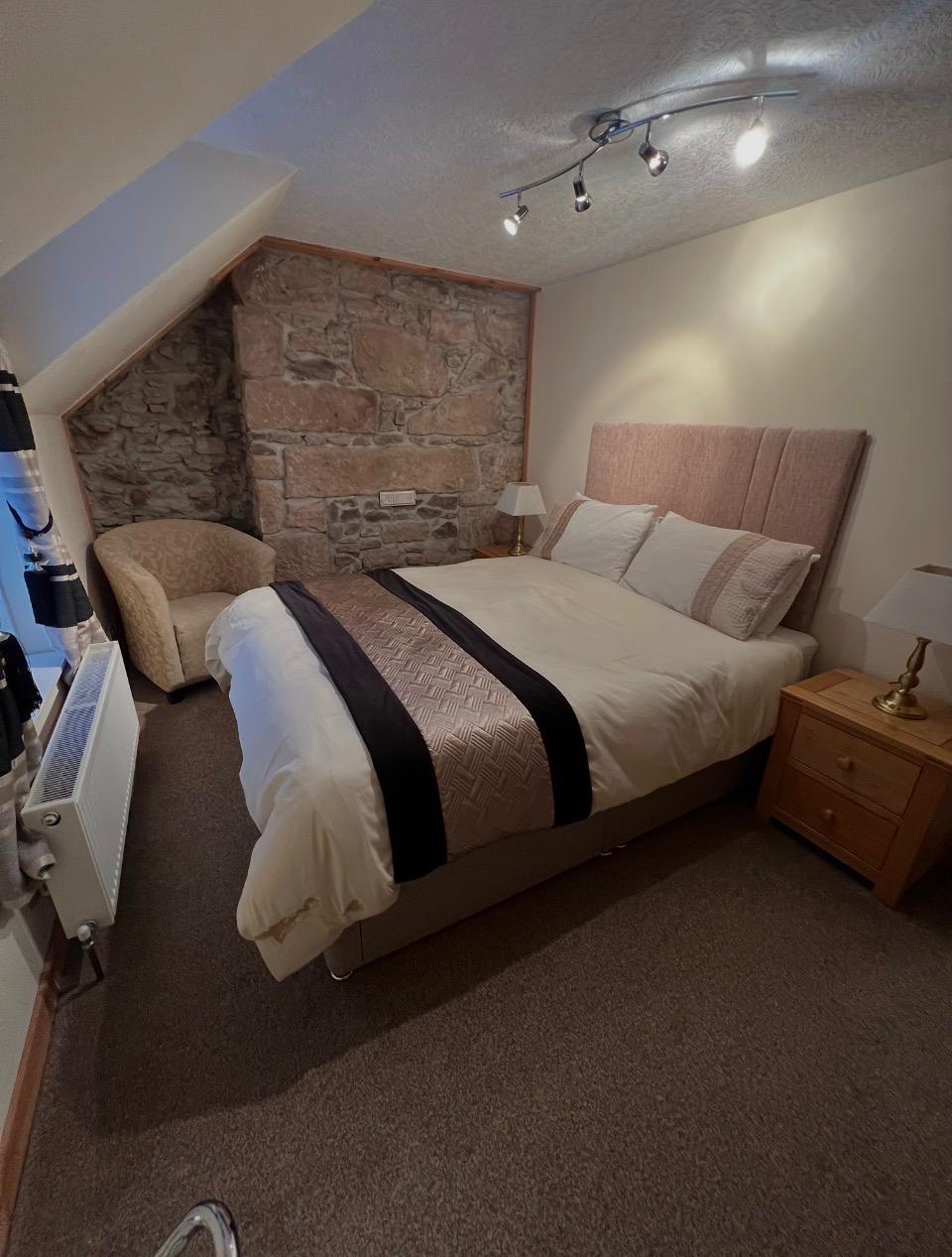 No.10 The Cottage king bedroom with stone feature wall
