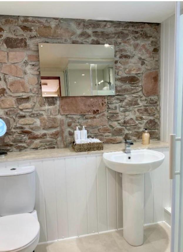 No.10 The Cottage shower room with stone feature wall